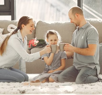 A joyful family enjoying quality time and coffee in a bright living room, symbolizing love and togetherness.