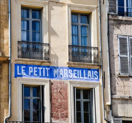 Charming building front with 'Le Petit Marseillais' in Aix-en-Provence, France.
