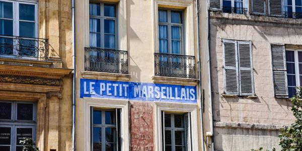 Charming building front with 'Le Petit Marseillais' in Aix-en-Provence, France.